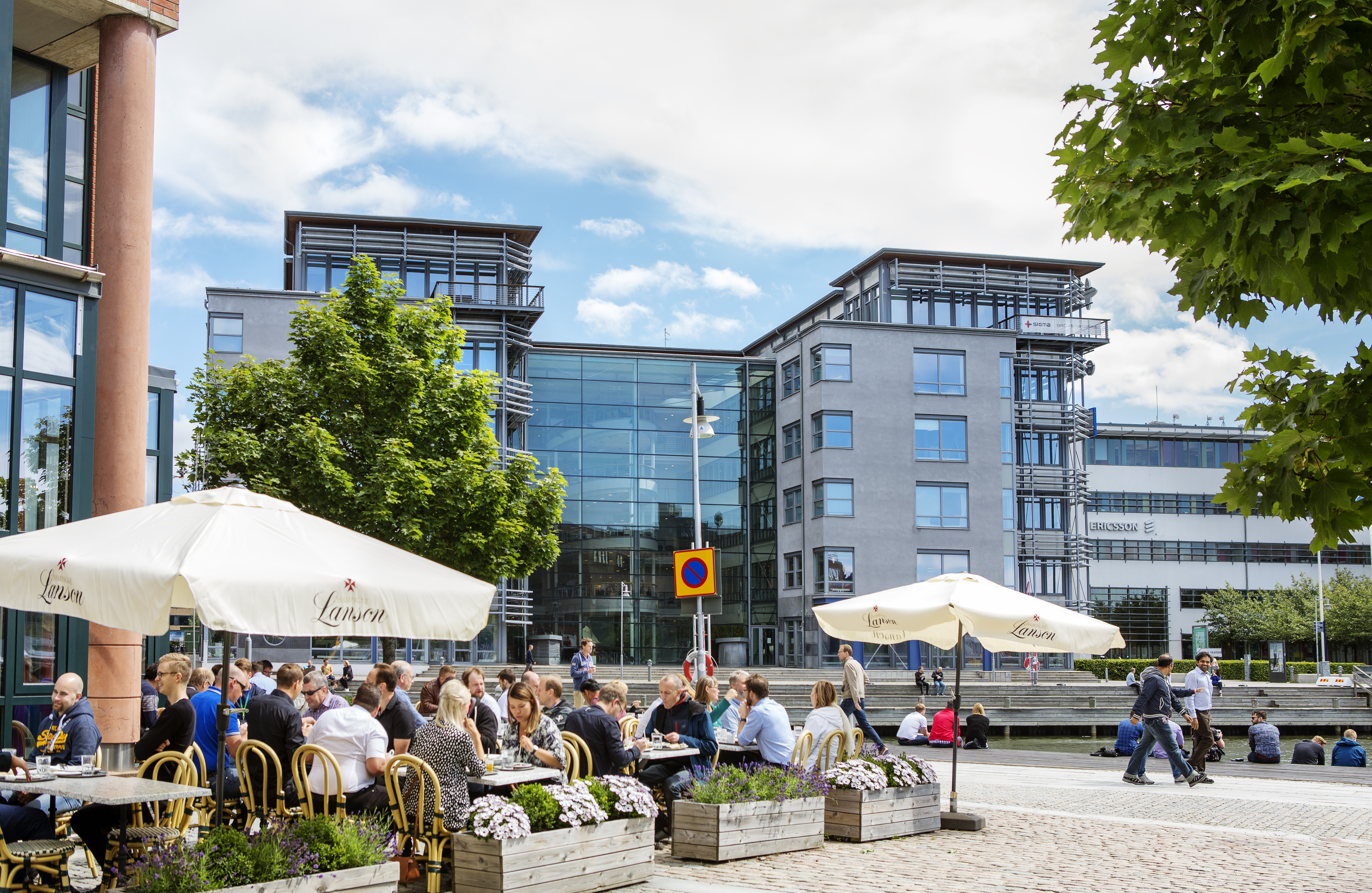 Lindholmspiren 9 och människor som fikar på torget.